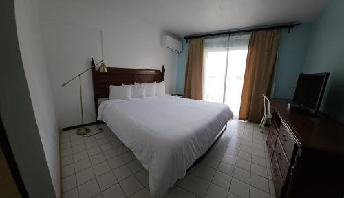 Our Accessible King Bed Room on the ground level offers comfort and ease, overlooking our tranquil pool area with a glimpse of the ocean. A peaceful base for your adults-only Luquillo escape.