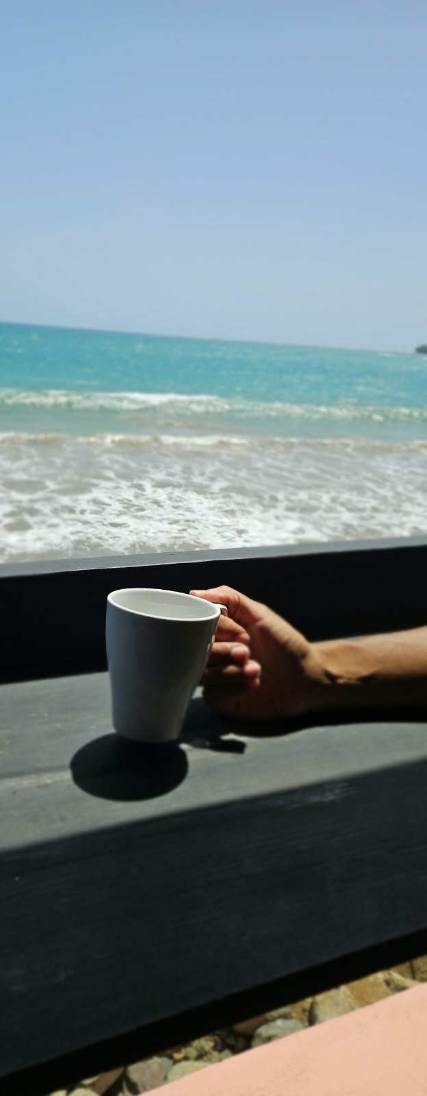 A drink on the bar at Selva On The Rocks with the ocean in the background